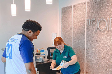 The Joint Chiropractic Apex Staff and Patient