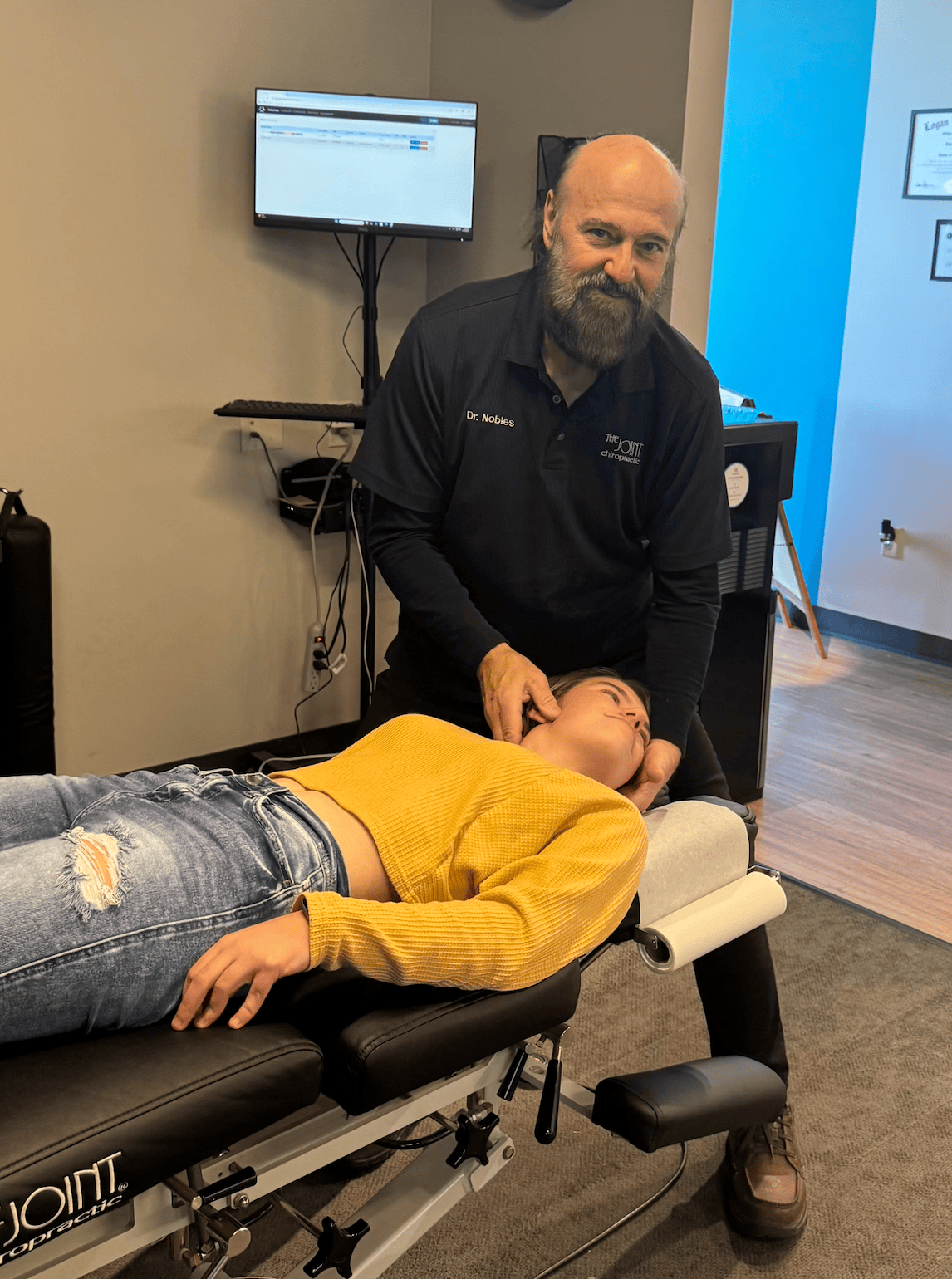 Dr. Nobles preparing to provide a neck adjustment to a patient at The Joint Chiropractic – Terre Hau