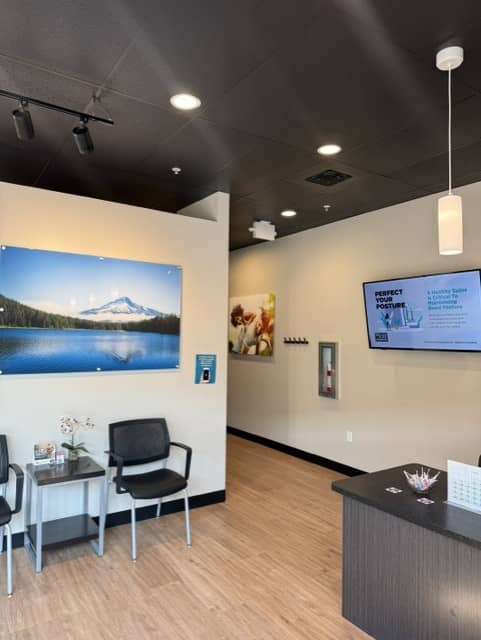Patient seating and front desk inside The Joint Chiropractic – Wood Village in Wood Village, OR